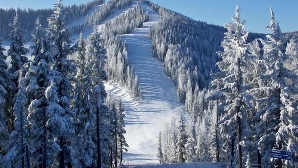 A snow-covered mountain with a ski slope.