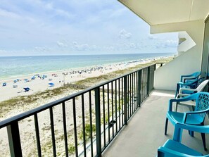 A balcony with a view of a beach, outdoor chairs, and a railing. - The Ocean Is Calling! Beachfront 2/2 Unit Pool & Ocean Next To Hangout (Gulf Shores)
