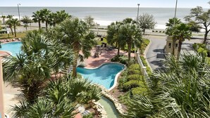 A resort with a swimming pool, palm trees, and a view of the beach. - GORGEOUS BEACH VIEW Legacy Towers T1-Unit 308/3 pools/Hot Tub/Close to Casinos (Gulfport)