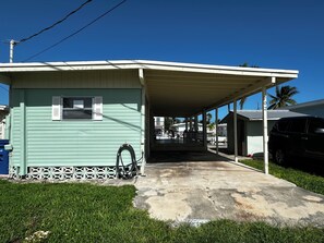 A small, single-story building with a covered porch and a concrete driveway.