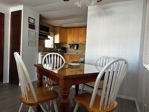Enjoy meals in this cozy dining area with a table and chairs, adjacent to a fully equipped kitchen.