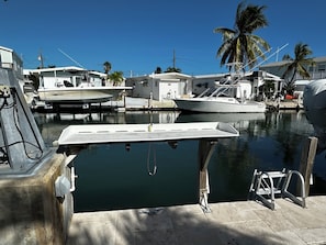 Guests can enjoy stunning marina views from the dock, with boats and a yacht moored nearby.