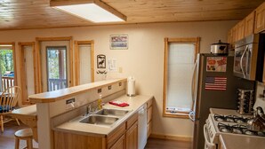 Una cocina con armarios de madera, un fregadero, una estufa y un refrigerador.