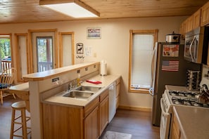 A kitchen with wooden cabinets, a sink, a stove, and a refrigerator.