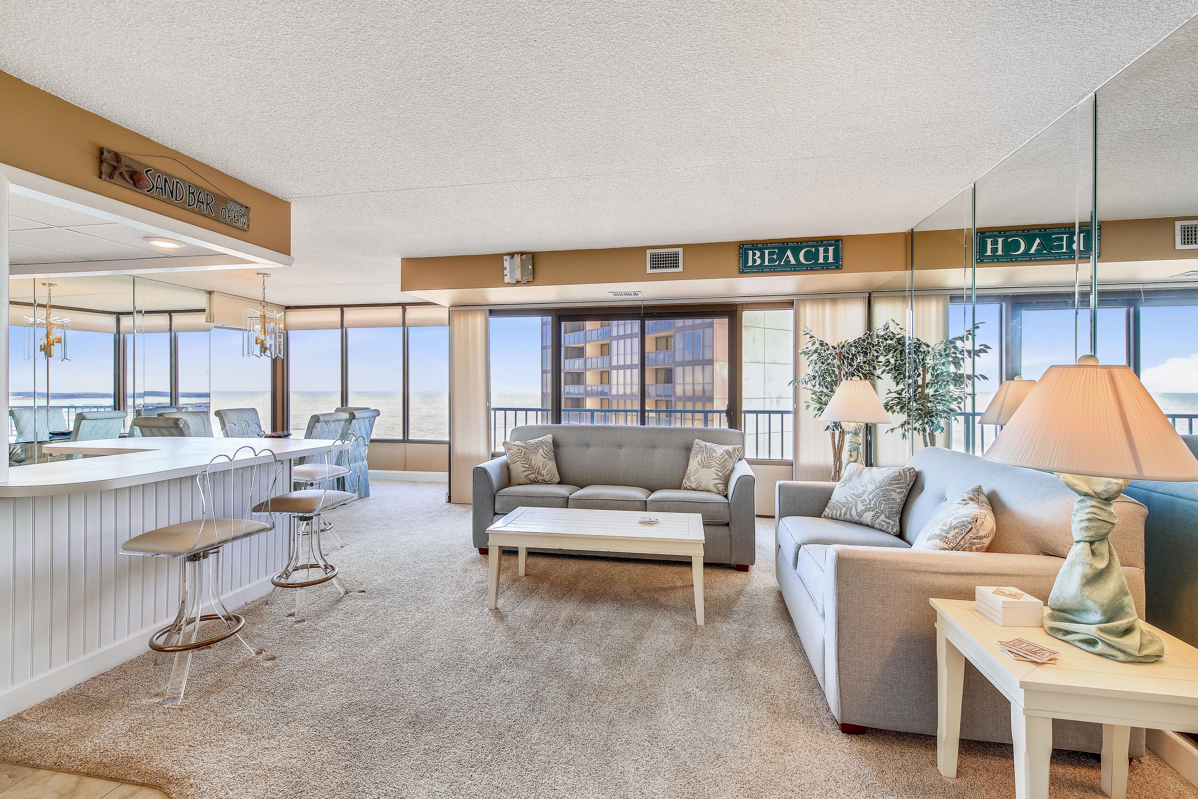 A modern hotel lobby with a bar area, seating, and large windows offering a view.