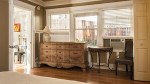 A room with a wooden dresser, a small table, a chair, and a window with blinds. - Classic & Central Hollywood Retreat with Porch and Garden (Los Angeles)