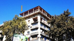 Un immeuble à plusieurs étages, doté de balcons et d’un toit rouge.