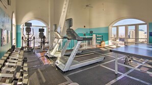 Ein Fitnessstudio mit Laufbändern, Trainingsgeräten und einem Tischtennis-Tisch.