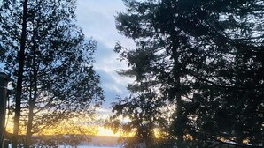Une piscine avec vue sur les arbres et sur le coucher de soleil.