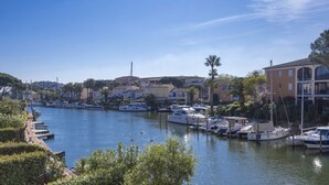 A marina with boats docked, surrounded by buildings and greenery. - Superb Fisherman's House with Private Pool / Mooring - Port Grimaud (Grimaud)