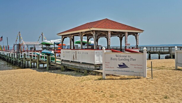 A pier with a covered seating area and a sign indicating it is a ferry landing pier offering kayaks, bikes, paddleboards, and pier rentals. - 'The Blue Crab Cottage' - 3 Blocks From The Beach! (Colonial Beach)
