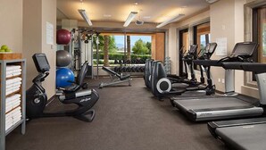Une salle de sport équipée de machines de cardio, de machines de musculation et d’haltères.