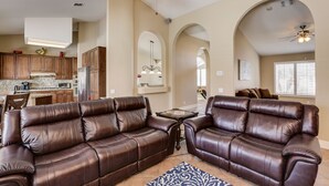A spacious living room with a brown leather sofa set, a coffee table, and a patterned rug. - Palm Desert Oasis For The Whole Family To Enjoy (Palm Desert)