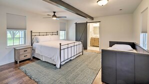 Une chambre à coucher avec un lit, une table de chevet et un ventilateur de plafond.