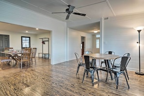 A spacious dining area with a wooden table and chairs, a ceiling fan, and a modern light fixture. - Fire Pit, Pickleball, Pool! Schulenburg Farmhouse (Schulenburg)