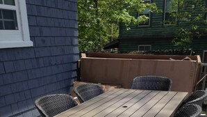 An outdoor patio with a wooden table and wicker chairs. - Beside The Tulip Tree - 3Bd Historic Home located in Waterfront District (Shelburne)
