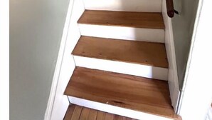 A staircase with wooden steps and white walls. - Beside The Tulip Tree - 3Bd Historic Home located in Waterfront District (Shelburne)