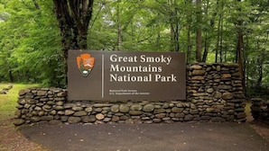 Señal para el Parque Nacional de las Montañas Humeantes, con un logotipo y texto.