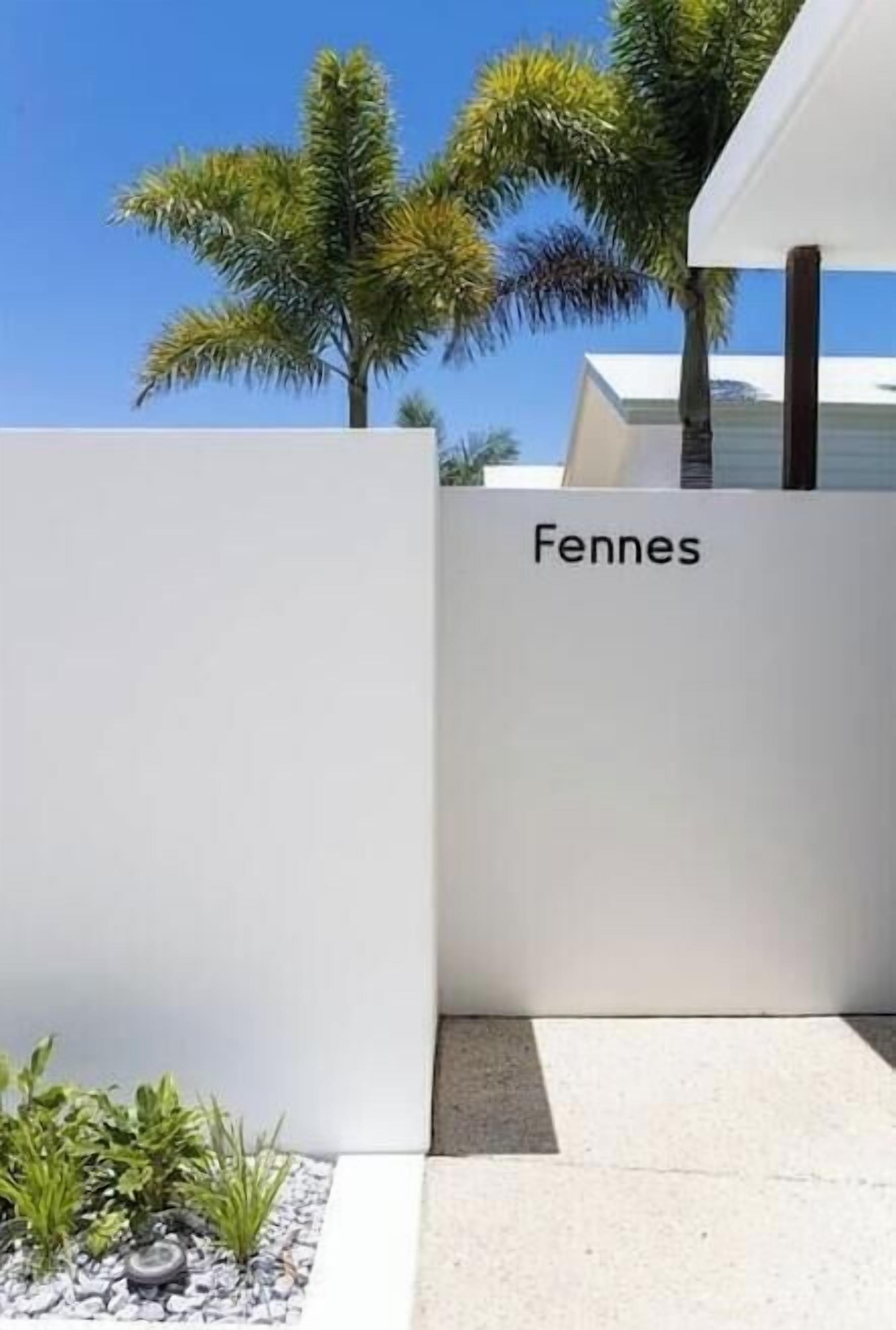 A modern building with a white facade and the name 'Fennes' on it.