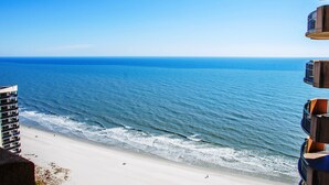 A beach view with a high-rise building in the foreground.