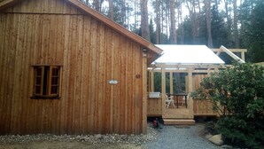 Une cabane en bois avec une véranda et une fenêtre.