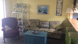 Ein Wohnzimmer mit einer Couch, einem Sessel und einem blauen Couchtisch.