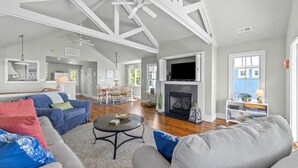 A spacious living room with a fireplace, a television, and a dining area. - Neuse Village #7 - Experience your inner peace! (Arapahoe)