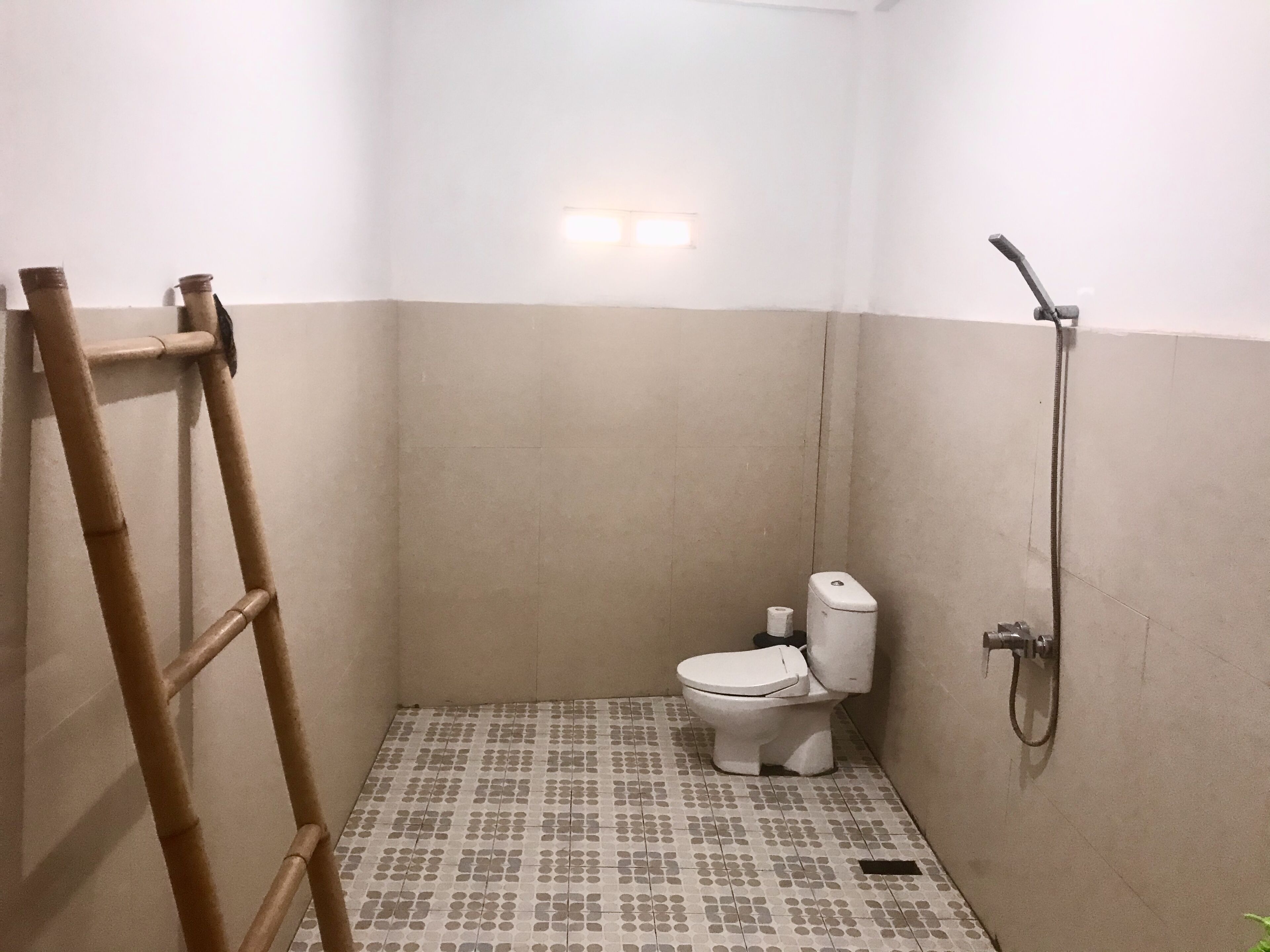 Un baño pequeño con inodoro, ducha y escalera.