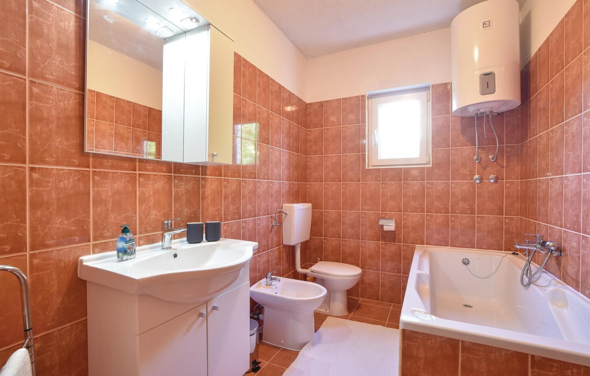Une salle de bain équipée d’un lavabo, d’un bidet, de toilettes et d’une baignoire.