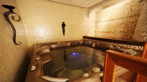 Un bain à remous doté d’un panneau de commande, entouré d’un mur carrelé et de meubles en bois.