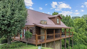 A log cabin with a wooden deck and a stone chimney. - Cozy Cabin|2 King Suites w/Jacuzzis |Near Dollywood (SEVIERVILLE)