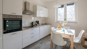 Eine moderne Küche mit weißen Schränken, einem eingebauten Backofen und einem Fenster mit Blick.