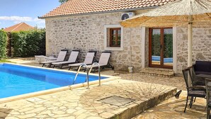 A stone building with a swimming pool, lounge chairs, and a covered seating area. - Amazing home in Lisane Tinjske (Lisane Tinjske)