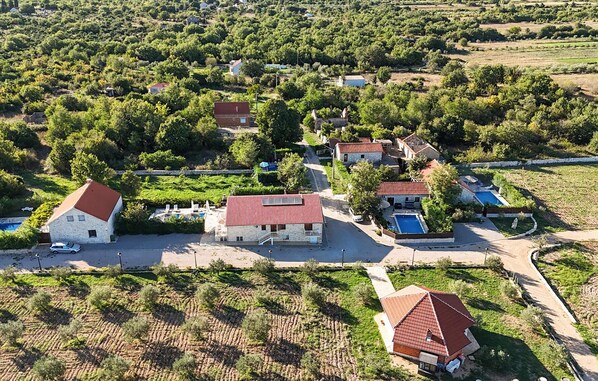 A rural property with multiple buildings, a swimming pool, and a vineyard.