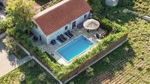An aerial view of a house with a swimming pool, surrounded by greenery and stone walls. - Amazing home in Lisane Tinjske (Lisane Tinjske)