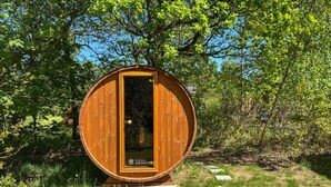 A wooden barrel-shaped structure with a door, surrounded by greenery. - Nice home in Ebeltoft with WiFi (Ebeltoft)
