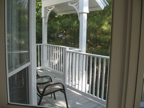 Relax on the covered porch with a bench and enjoy the serene views of the lush landscape.