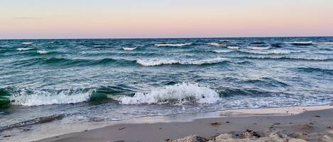 Een strand met golven die op de kust breken.