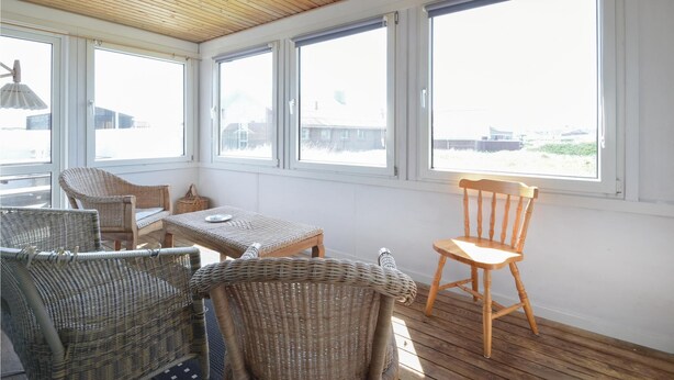 A sunlit room with wicker furniture, large windows, and a wooden ceiling. - 3 bedroom amazing home in Frøstrup (Frøstrup)