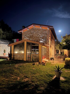 A stone house with a glass front, a small porch, and a garden. - the Casellina (Casa Biondo)
