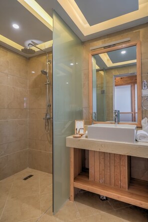A modern bathroom with a glass-enclosed shower, a wooden vanity, and a large mirror. - Floral Hotel Lijiang Huazizai (Lijiang)