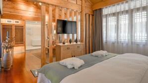 A wooden room with a bed, a TV, and a wooden cabinet. - Floral Hotel Lijiang Huazizai (Lijiang)