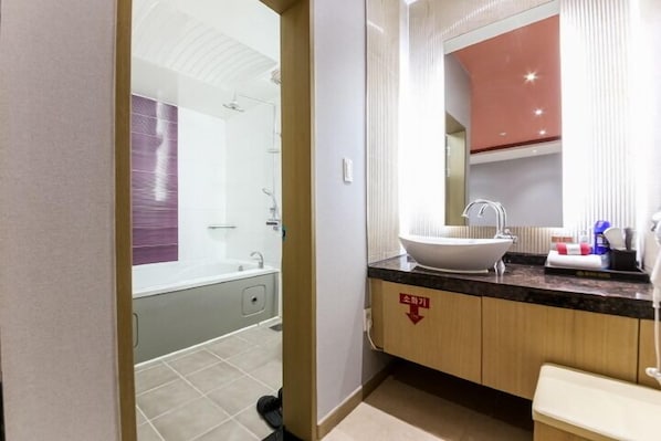 A modern bathroom with a bathtub, a sink, and a mirror. - Gallery Hotel (Gwangju)