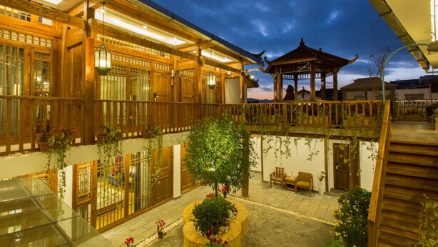 A traditional wooden building with a covered courtyard, featuring a gazebo and potted plants. - Floral Hotel Lijiang Exclusive Memory (Lijiang)