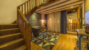 A staircase with wooden railings leading to a room with a geometric patterned rug, a table, and a chair. - Floral Hotel Lijiang Exclusive Memory (Lijiang)