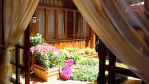 Une structure en bois dotée d’une fenêtre et d’un jardin où poussent diverses plantes et fleurs.