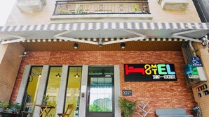 A hotel with a sign reading "HOTEL MEL" and a wheelchair-accessible parking sign.