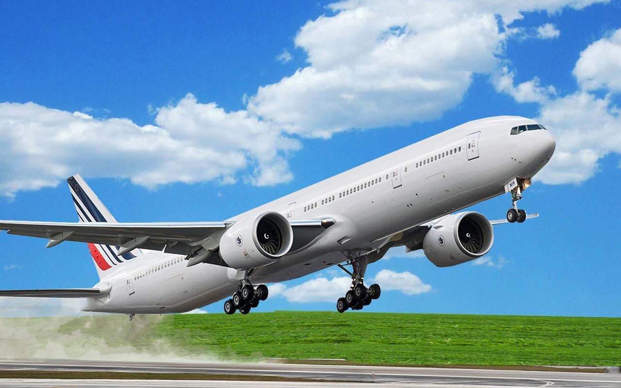 A large commercial airplane in mid-flight with visible landing gear and a clear blue sky with clouds in the background.