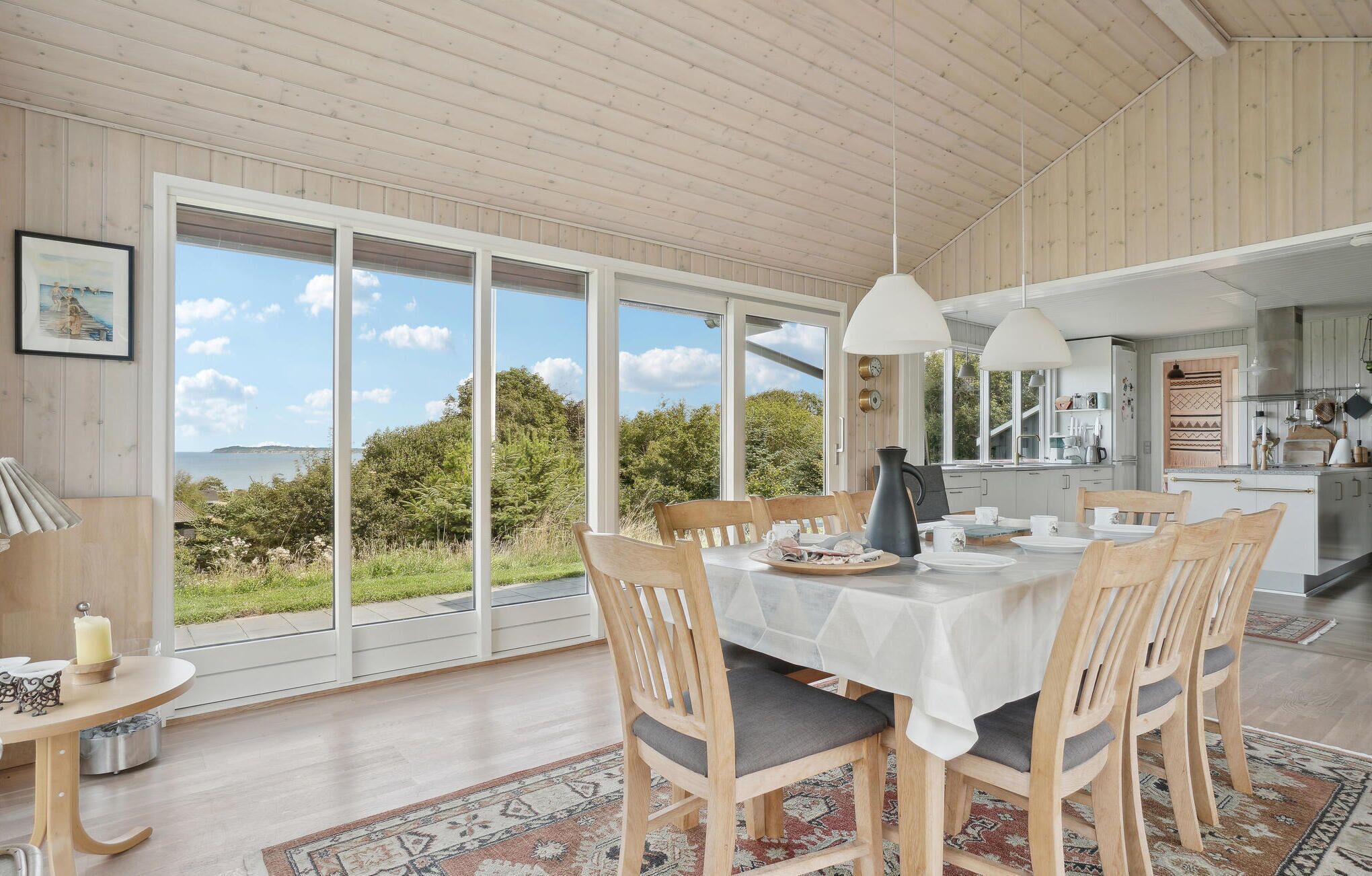 A dining area with a table set for four, large windows, and a view of the outdoors.