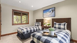 A bedroom with two beds, a window, a painting, and a bedside table with a lamp and plants. - Rare 3BR + Den 2-Min Walk to Park City Ski Base! (Park City)